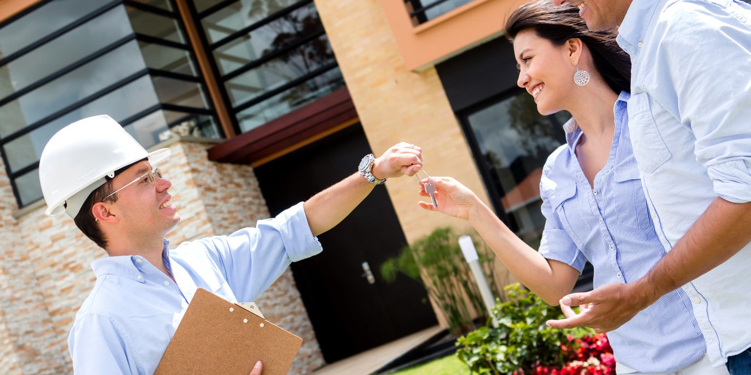 Architect handling keys to a couple